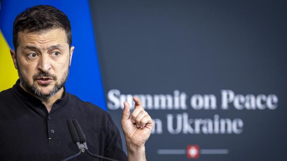 Ukrainian President Volodymyr Zelensky addressing attendees at the peace summit from a lectern 