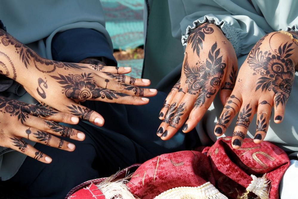 Muslim women display their henna decorations