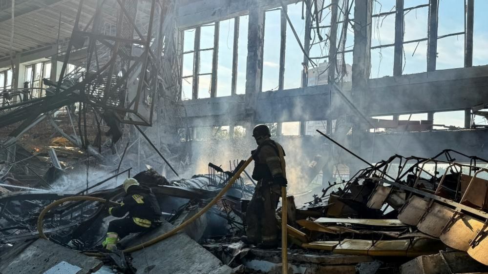 Firefighters inside a building hit by a Russian air strike in Kharkiv