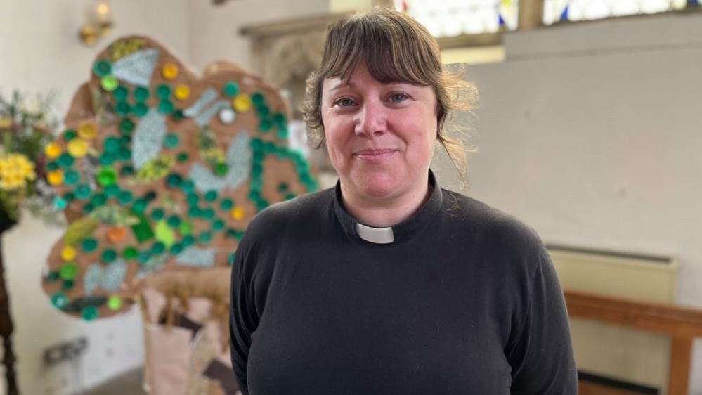 Reverend Natalie Rees, pictured next to a sculpture of a tree