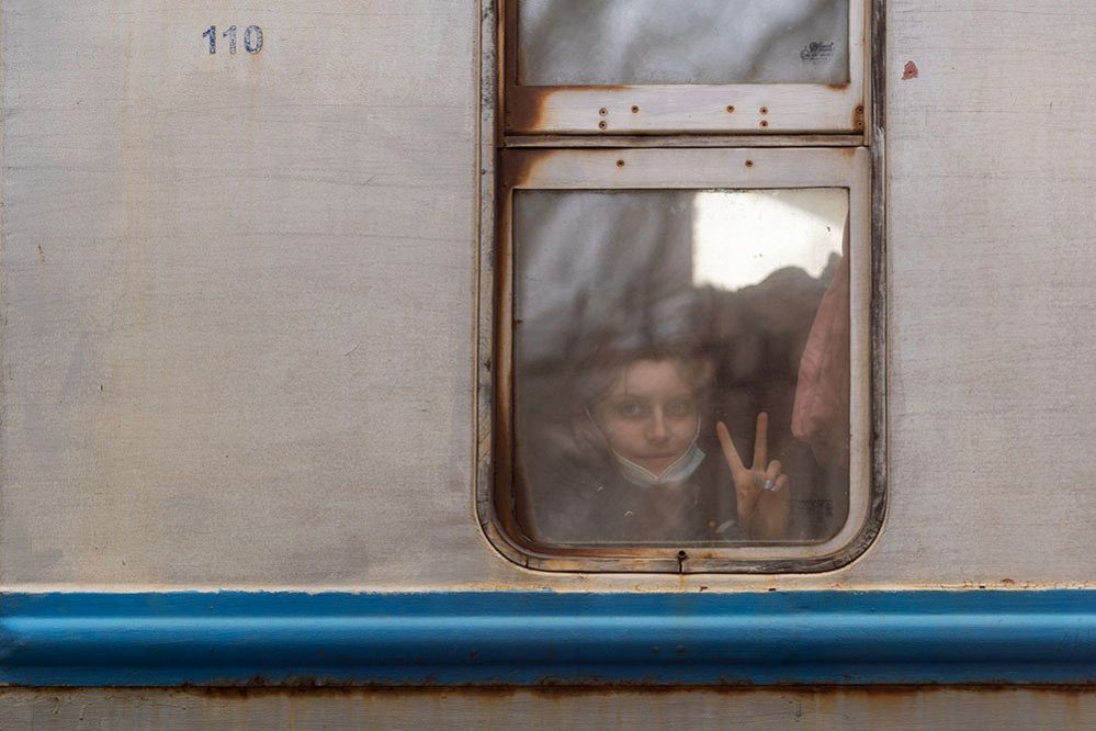 Young Ukrainian refugee shows V sign after arriving in Przemysl, Poland