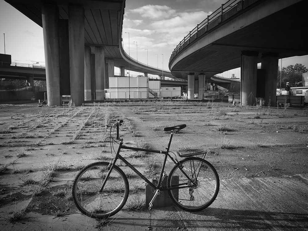 An abandoned bike below a flyover