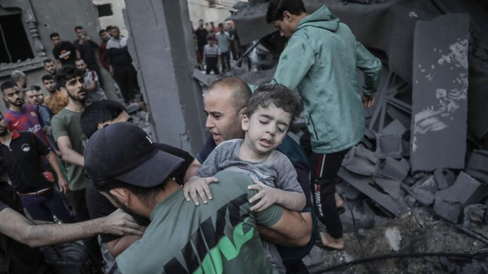 A child is recovered from the rubble of a building hit in an Israeli airstrike, in Khan Younis refugee camp, in Gaza (October 2023)