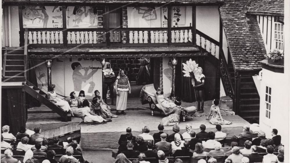 Black and white image of audience watching play