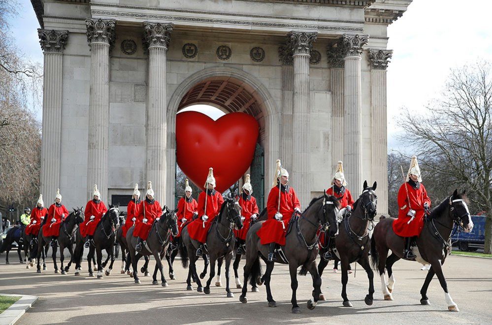 Members of the Household Cavalry pass the Wellington Arch and a large inflatable heart,