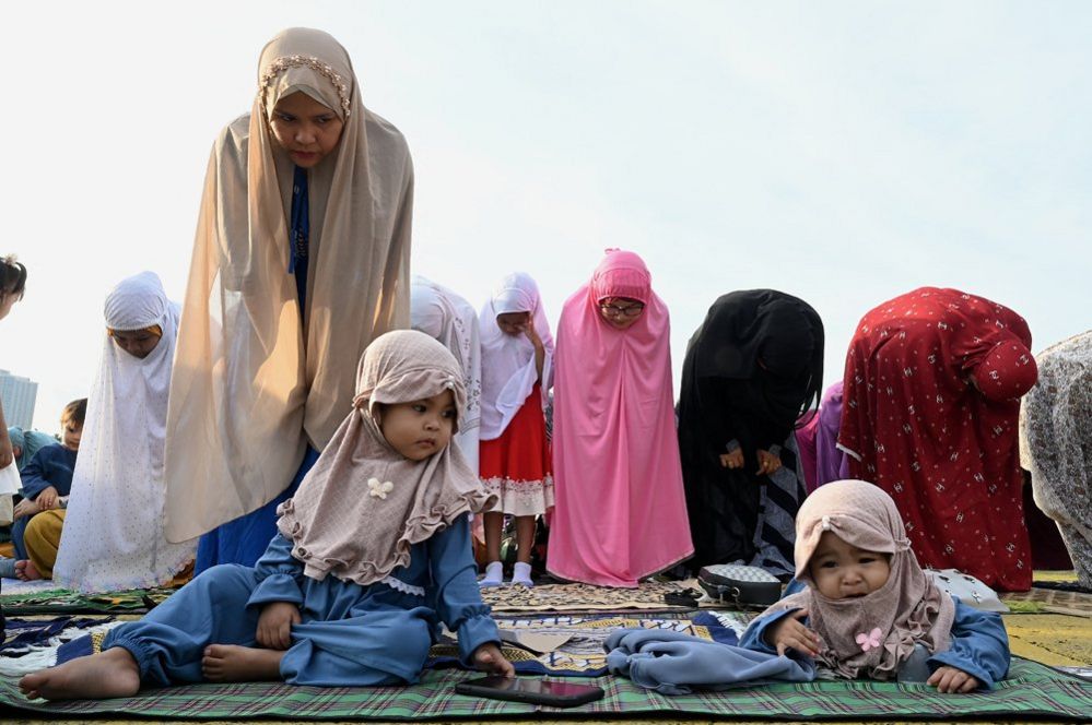 Мусульмане принимают участие в утренней молитве в честь праздника Курбан-Байрам на трибуне Квирино в Маниле, Филиппины