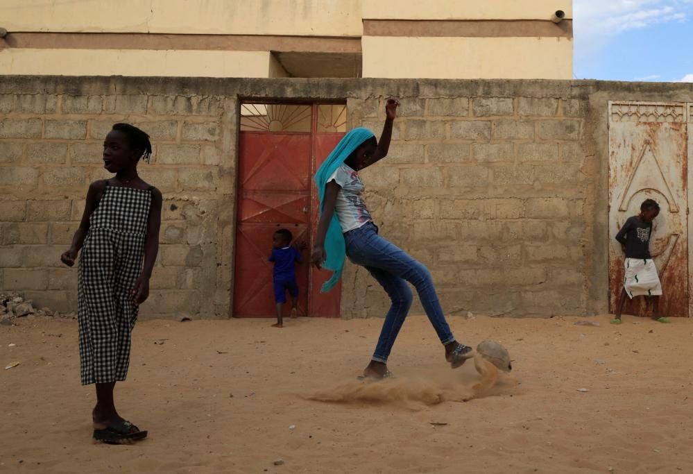Maty Diop plays football outside her house