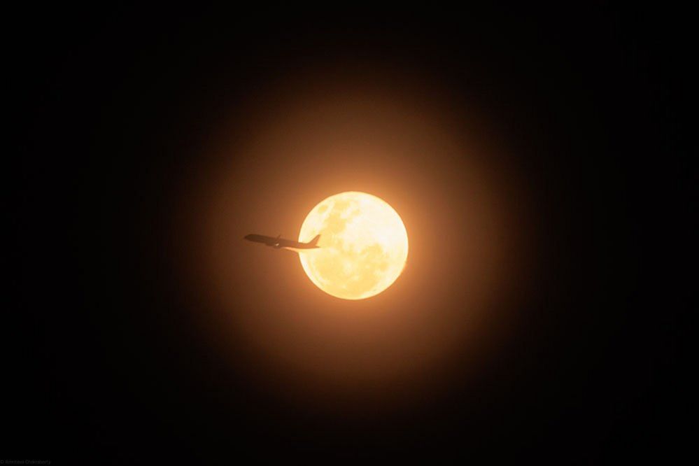 An aircraft in front of the moon