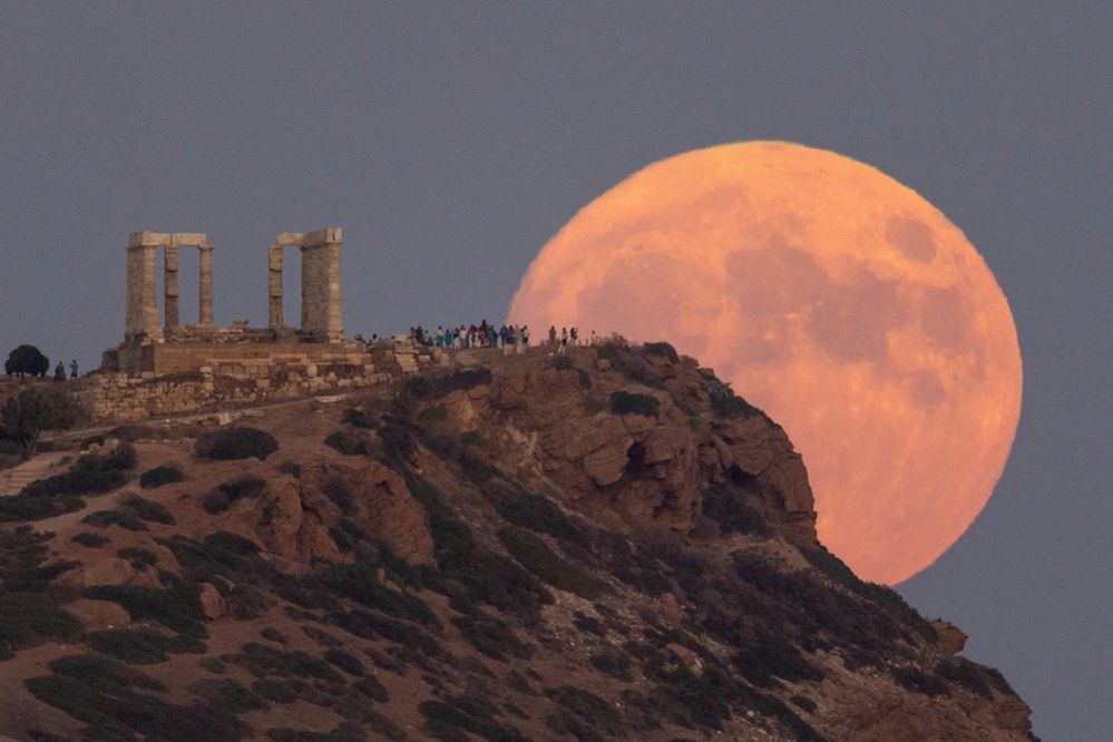 A full moon known as the "Blue Moon" rises behind the Temple of Poseidon, in Cape Sounion, near Athens, Greece, August 30
