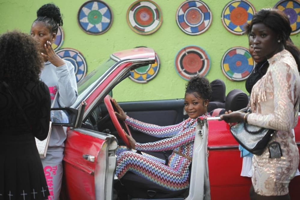A woman poses in a Mercedes car
