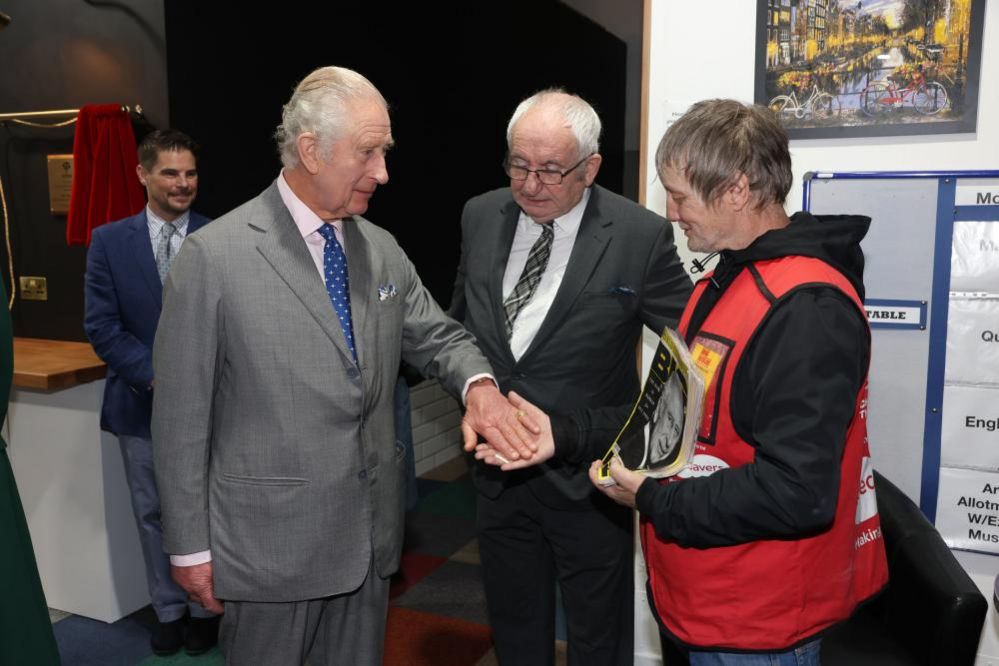 King Charles III buys a copy of the Big Issue from seller Kelvin along with Lord John Bird, founder of the magazine