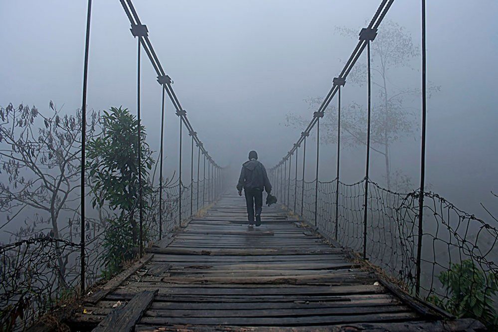 Фигура на мосту в тумане