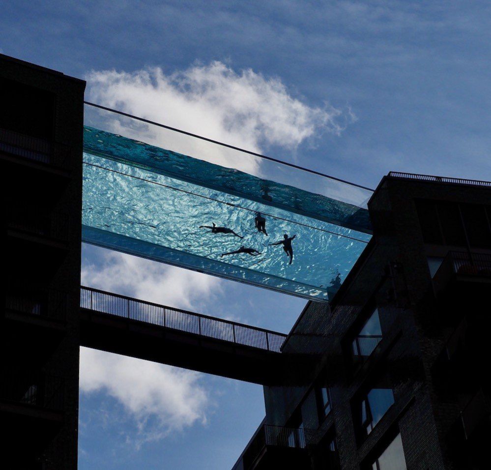 A swimming pool between two buildings seen from below