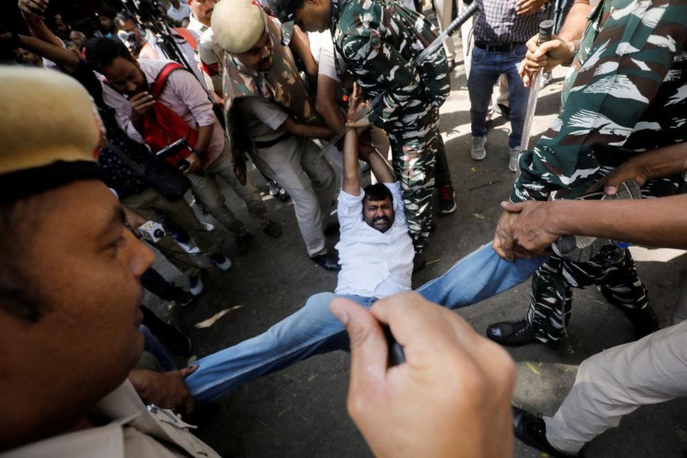 Police officers detain a supporter of India's main opposition Congress party during a protest in New Delhi, India