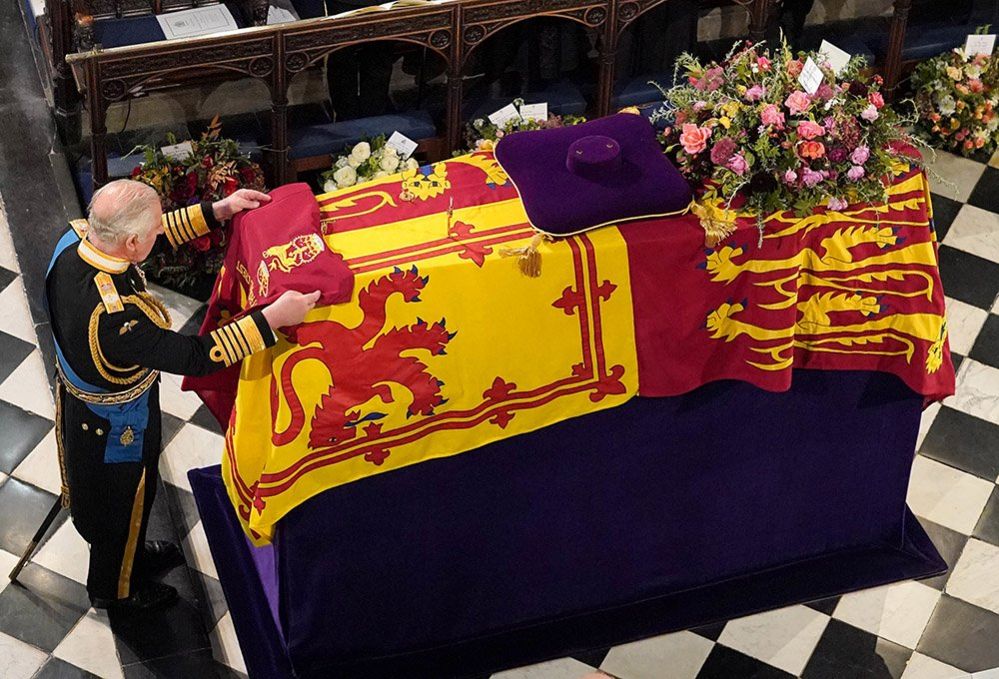 King Charles III places the the Queen's Company Camp Colour of the Grenadier Guards on the coffin at the Committal Service for Queen Elizabeth II, held at St George's Chapel in Windsor Castle, Berkshire, 19 September 2022