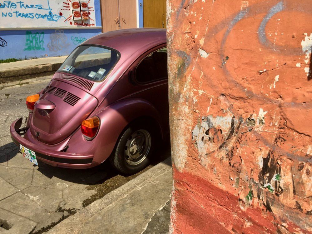 Volkswagen Beetle sticking out from behind the corner of a wall