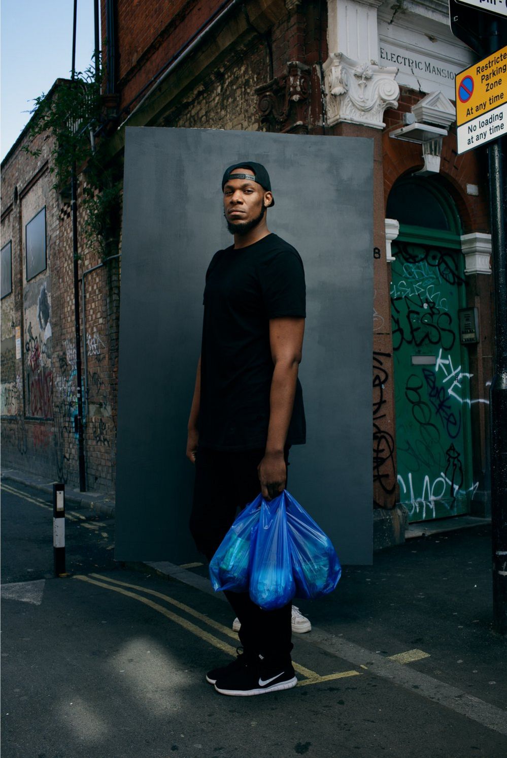 Portrait of a man in the street holding plastic bags