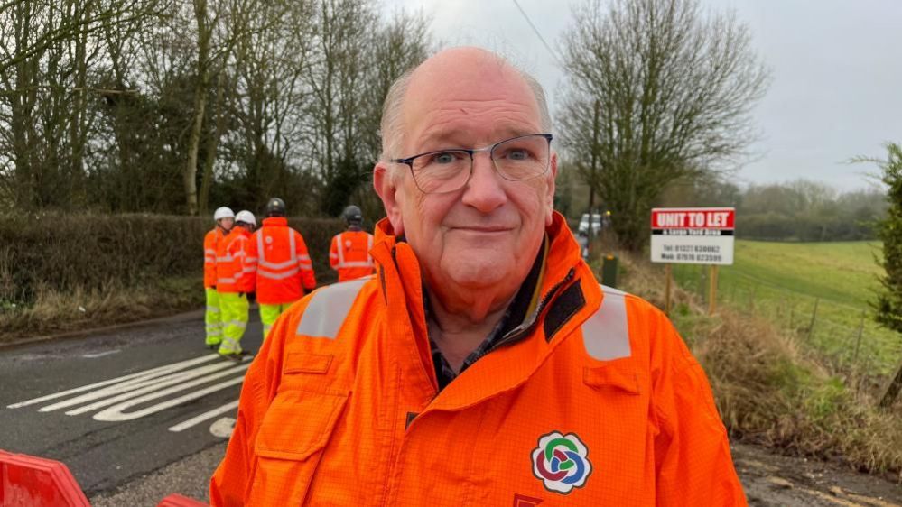 Councillor Phil Larratt in an orange high-vis jacket standing outside