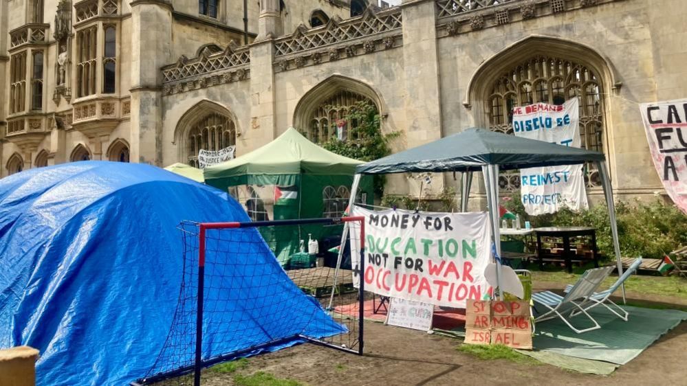 Two gazebos and a shelter made of blue sheeting at the Gaza war protest camp