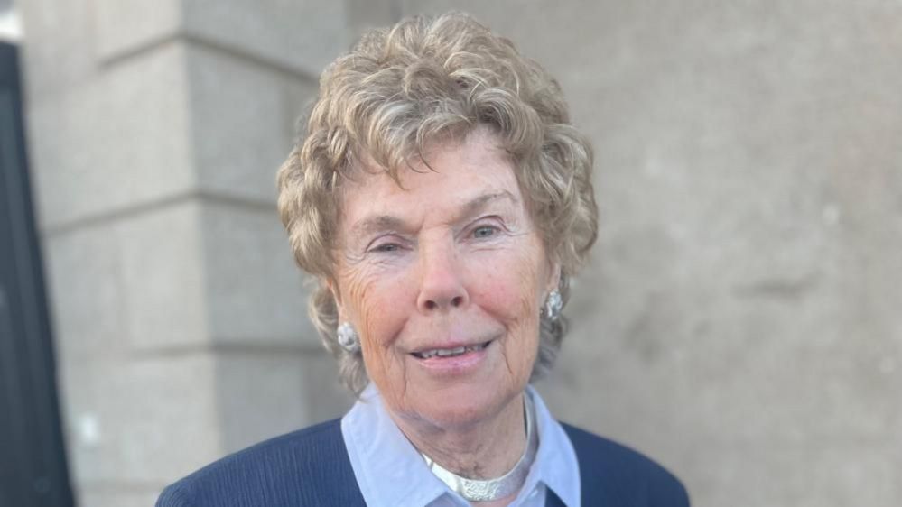 Baroness Hoey with curly fair hair and large earrings