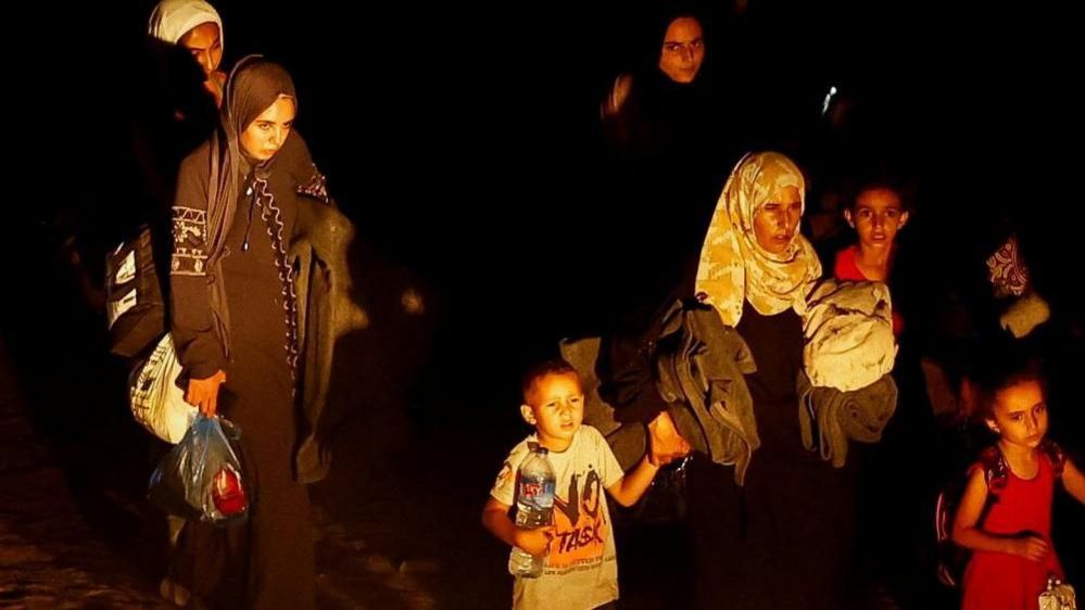 Palestinian women and children flee at night after the Israeli order