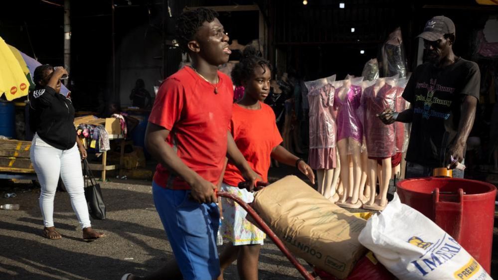 People buy supplies at the downtown street market as Hurricane Beryl approaches, in Kingston, Jamaica, July 2, 2024.