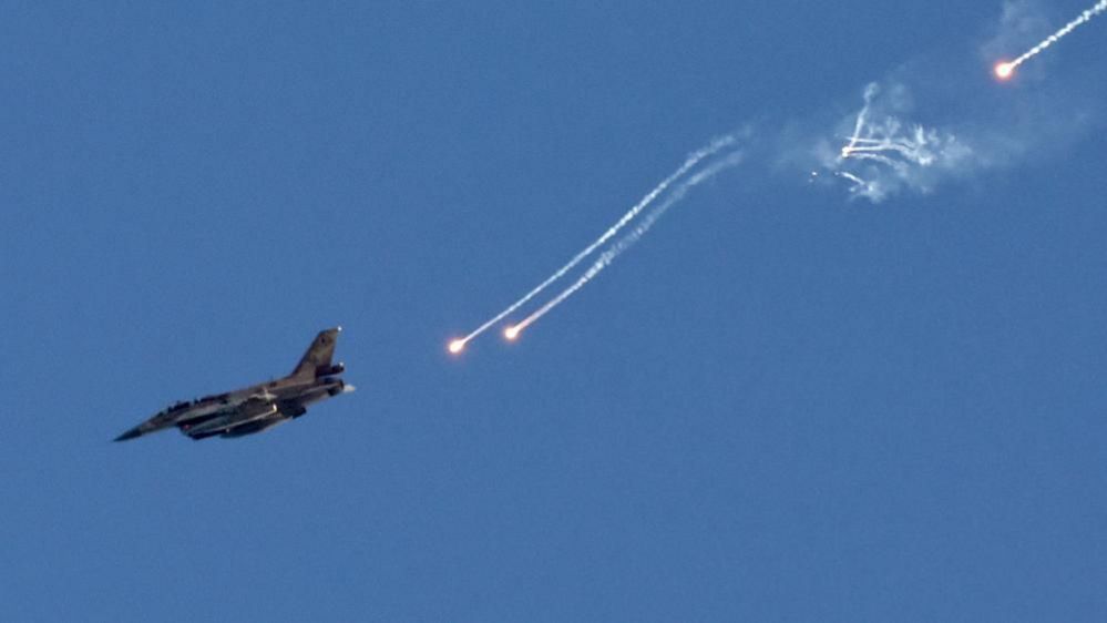 An Israeli fighter jet ejects flares over an area near the Lebanon-Israel border