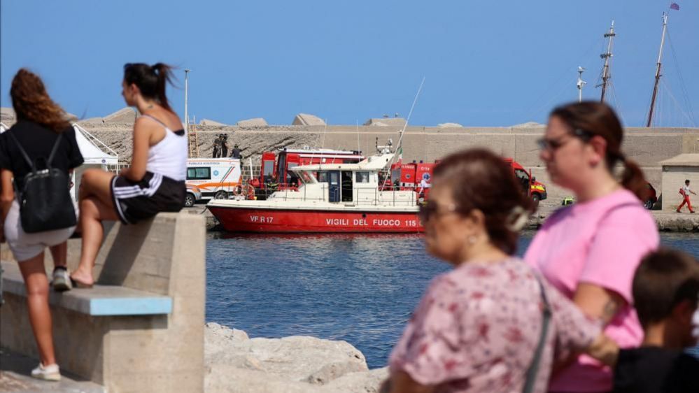 People watch rescue team near yacht sinking site