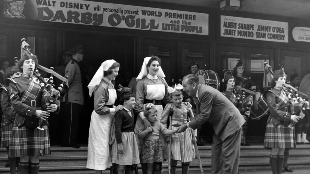 Walt Disney talks to children outside a theatre in Dublin in 1959