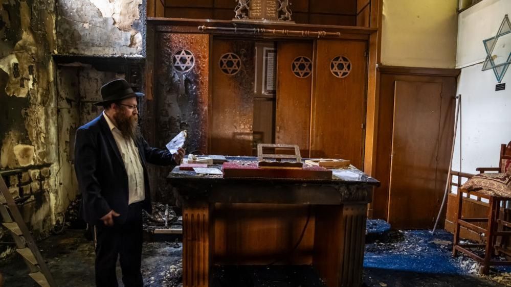 Rabbi of Rouen Chmouel Lubecki inspects the damage inside the synagogue after a man was shot by police while attempting to set it on fire, in Rouen, northern France, 17 May 2024