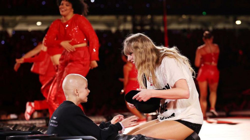 Taylor Swift gives a hat to a fan