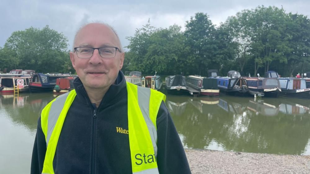 Peter Johns wearing a yellow hi-vis jacket next to the canal