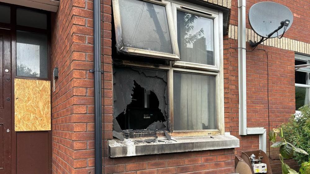 Smashed window of property and burnt parts of window 