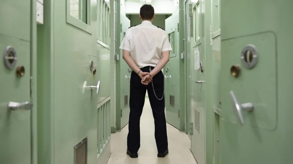 Prison guard standing in front of a door