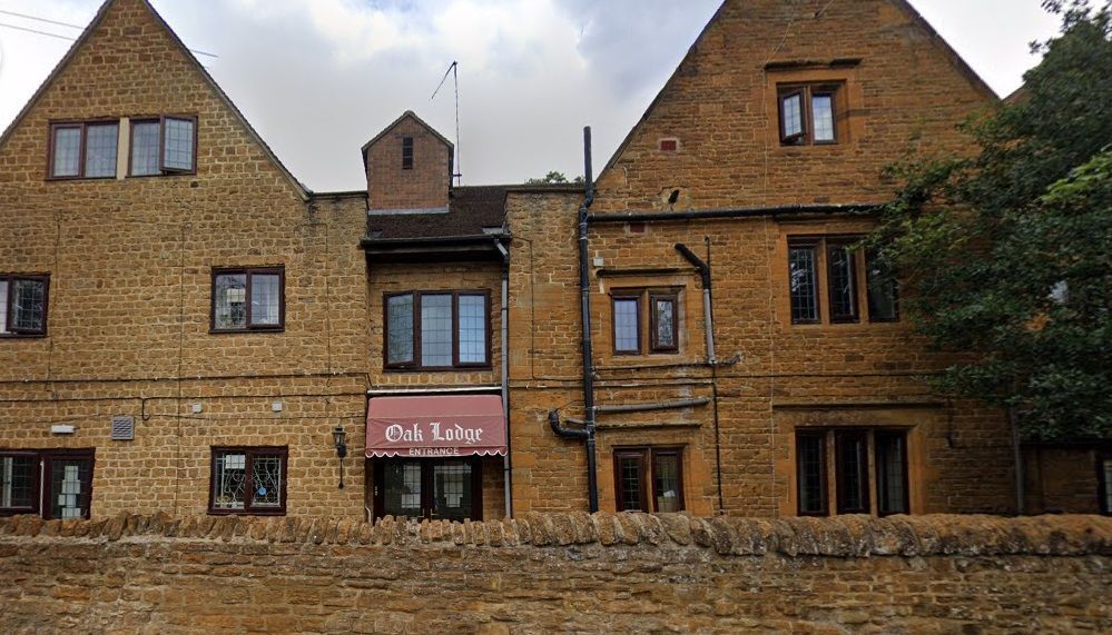 Side view of three-story brick-built care home with Oak Lodge sign above window