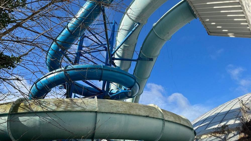 Shot looking up at huge pool slides that come out from the side of the building