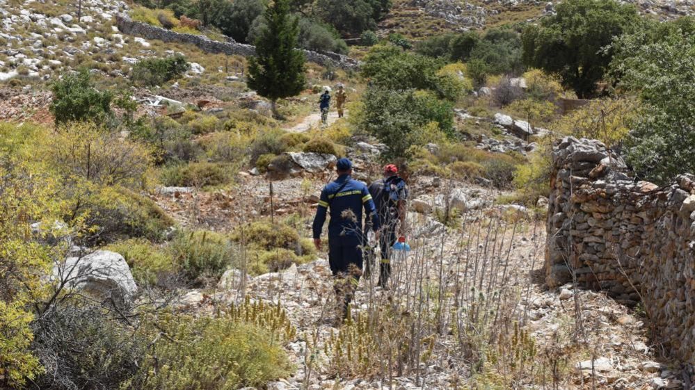A search and rescue team walking on the island of Symi, looking for missing TV presenter Michael Mosley