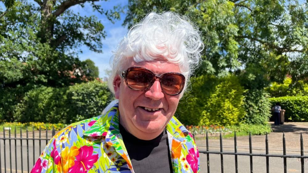 Adrian Thompson, chairman of Filby in Bloom, dressed in 1960s clothes and wig