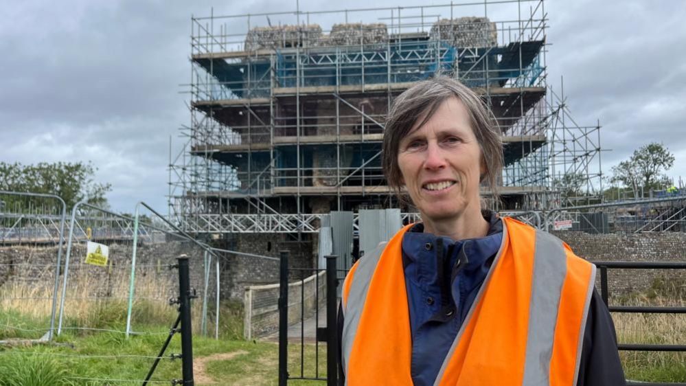 Ruth Brennan wearing a high-visibility jacket near the inner gatehouse of Baconsthorpe Castle