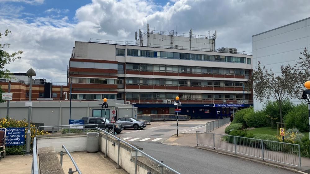 Four storey glass and brick hospital building with road 