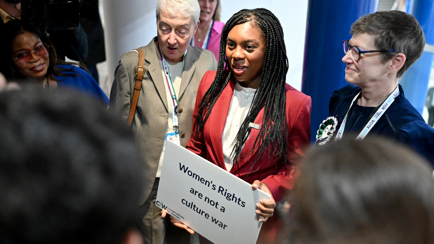 Kemi Badenoch na conferência conservadora de 2024, segurando uma placa onde se lê 