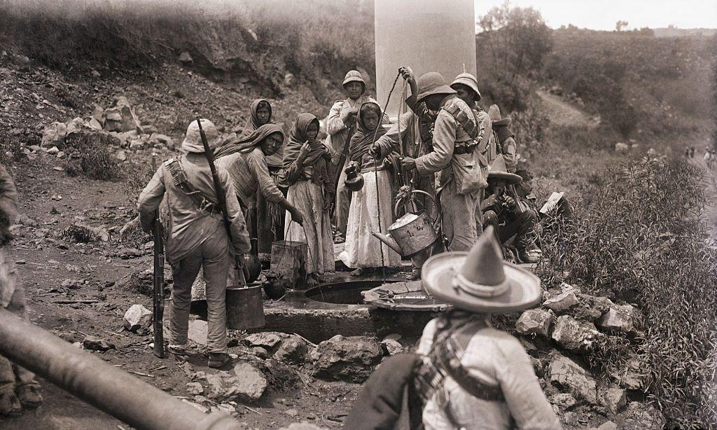 Hombres y mujeres junto a un pozo en la Revolución Mexicana.