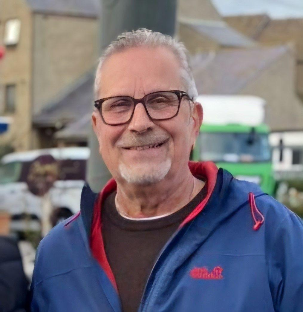 Alistair Dougal de óculos sorrindo para a câmera