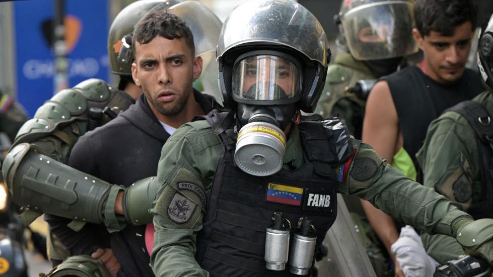 Dos jóvenes detenidos a principios de agosto son llevados por agentes de la Guardia Nacional de Venezuela