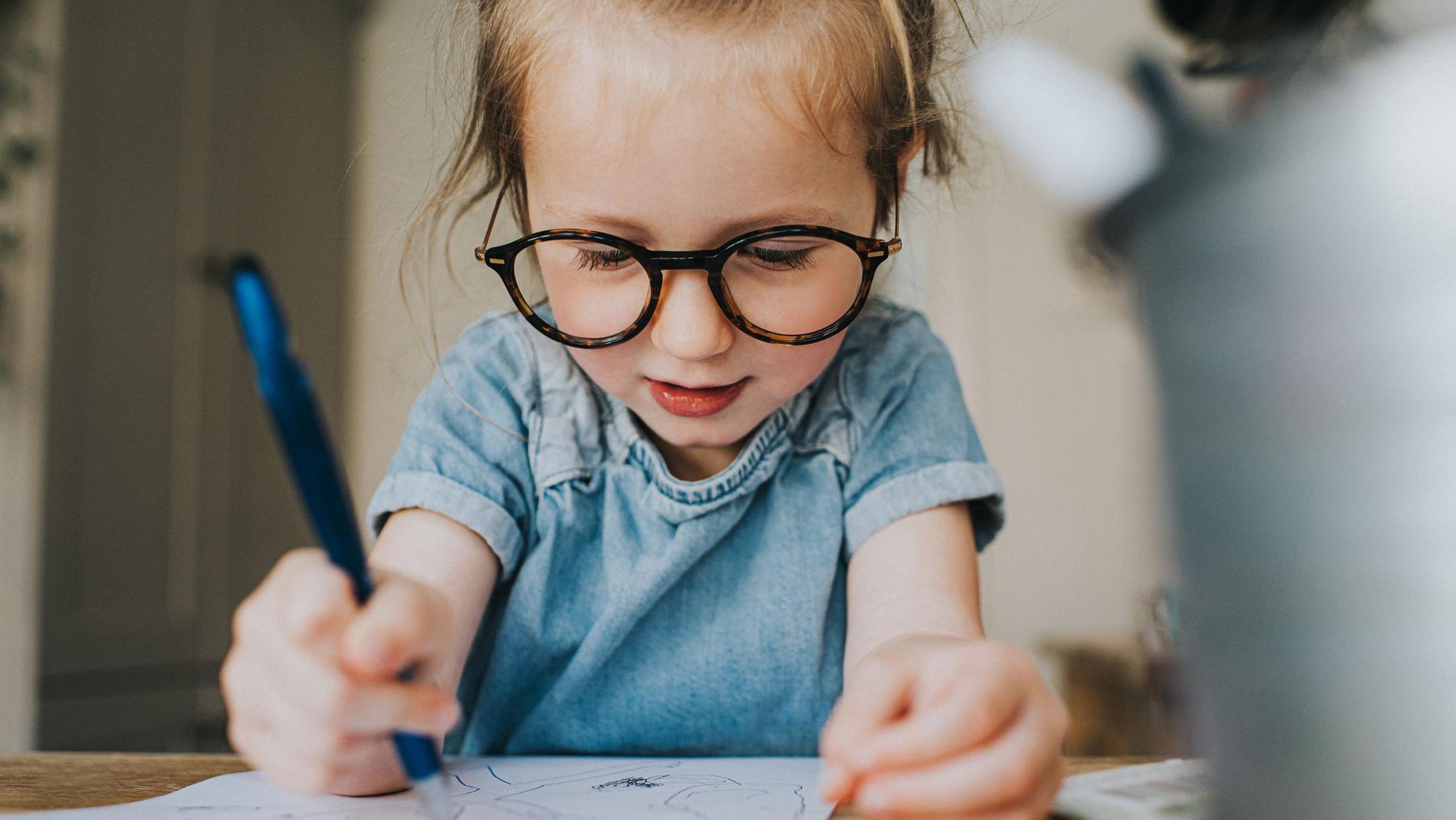 Una niña escribe a mano. 