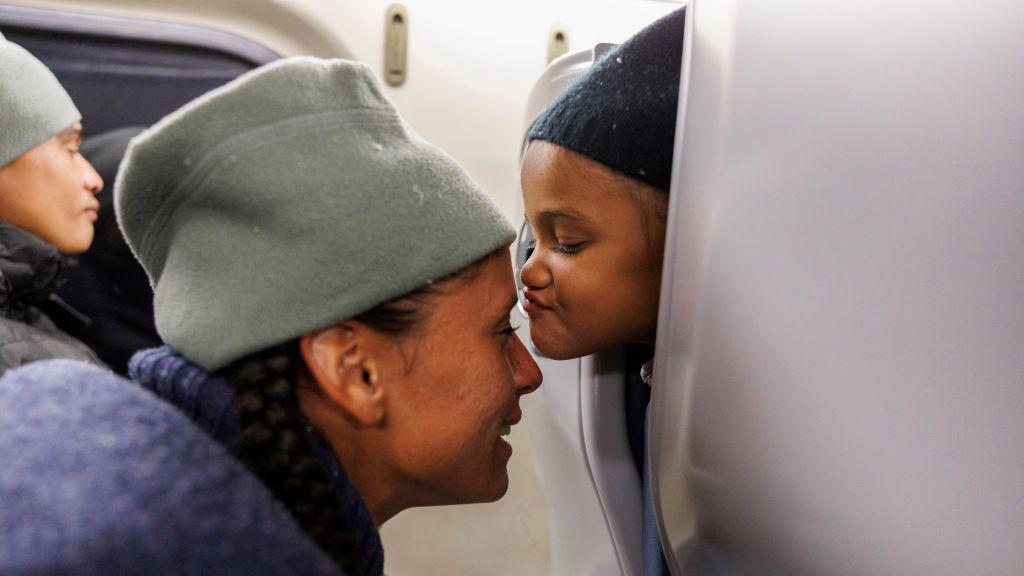 Una niña migrante besa a su madre.