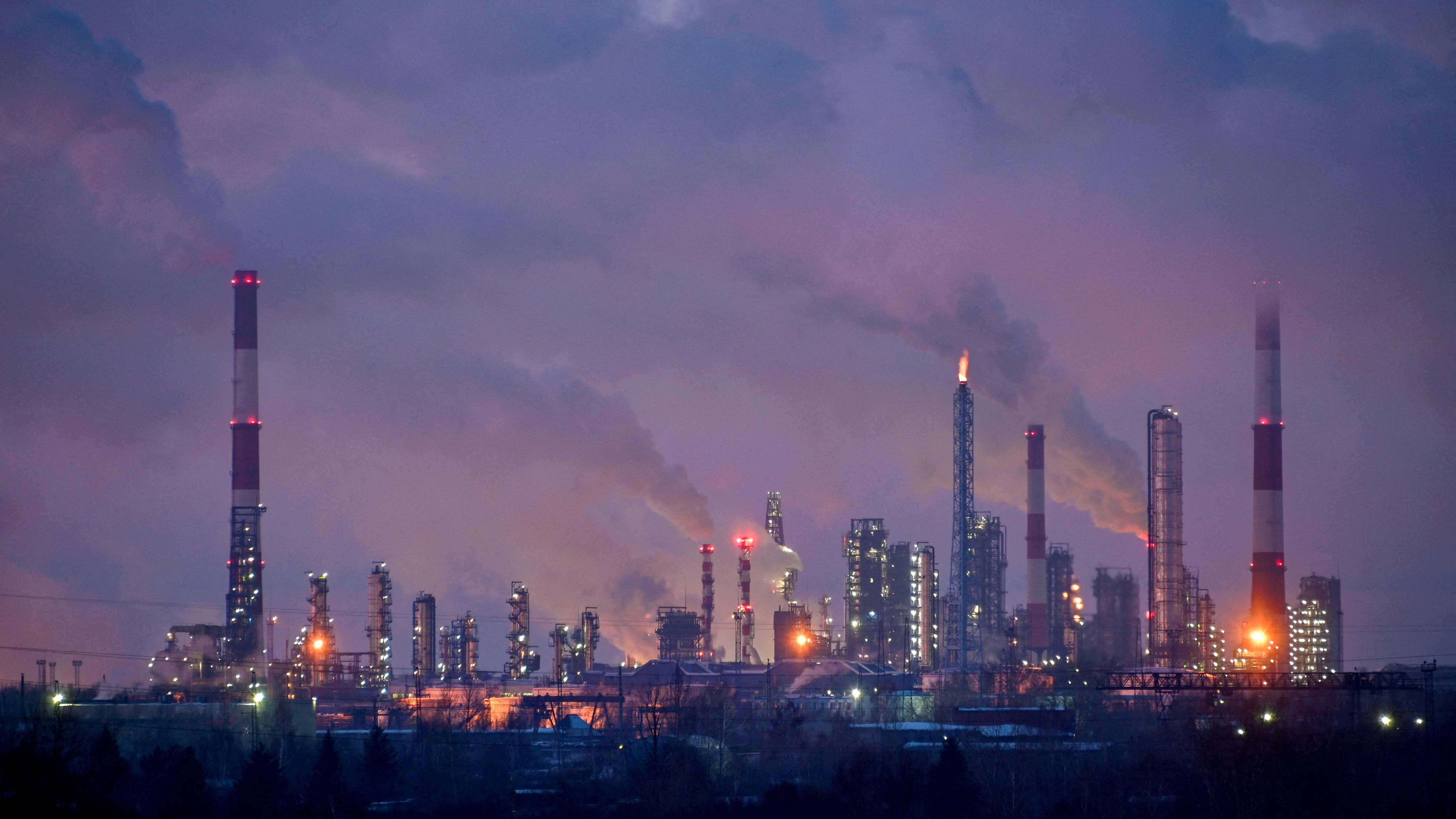 Flames and steam rising out of chimneys at night at an oil refinery in Omsk in Siberia, Russia.