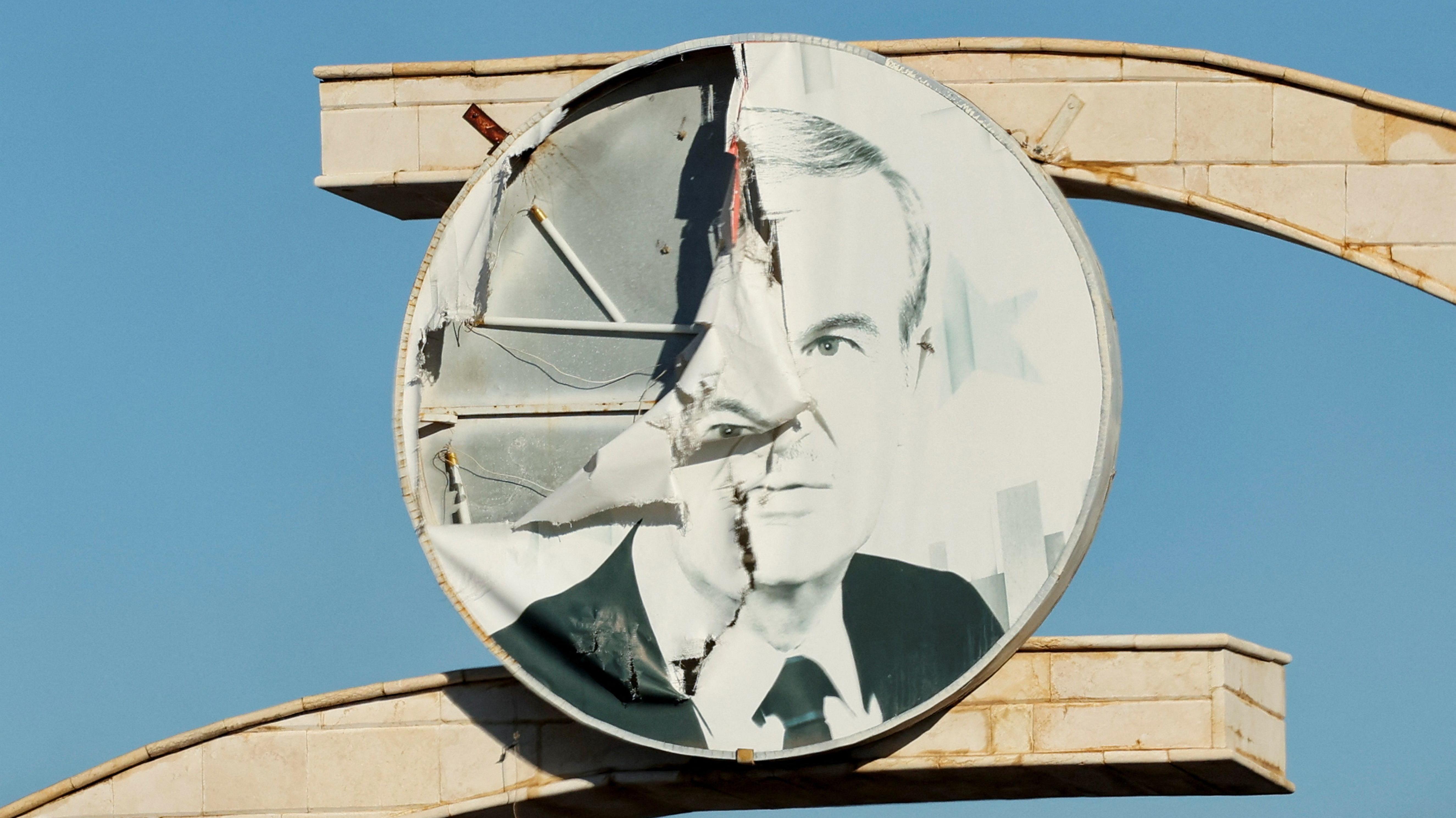 صورة ممزقة للرئيس السوري الراحل حافظ الأسد بالقرب من الحدود اللبنانية السورية، في 1 يناير/كانون الثاني 2025