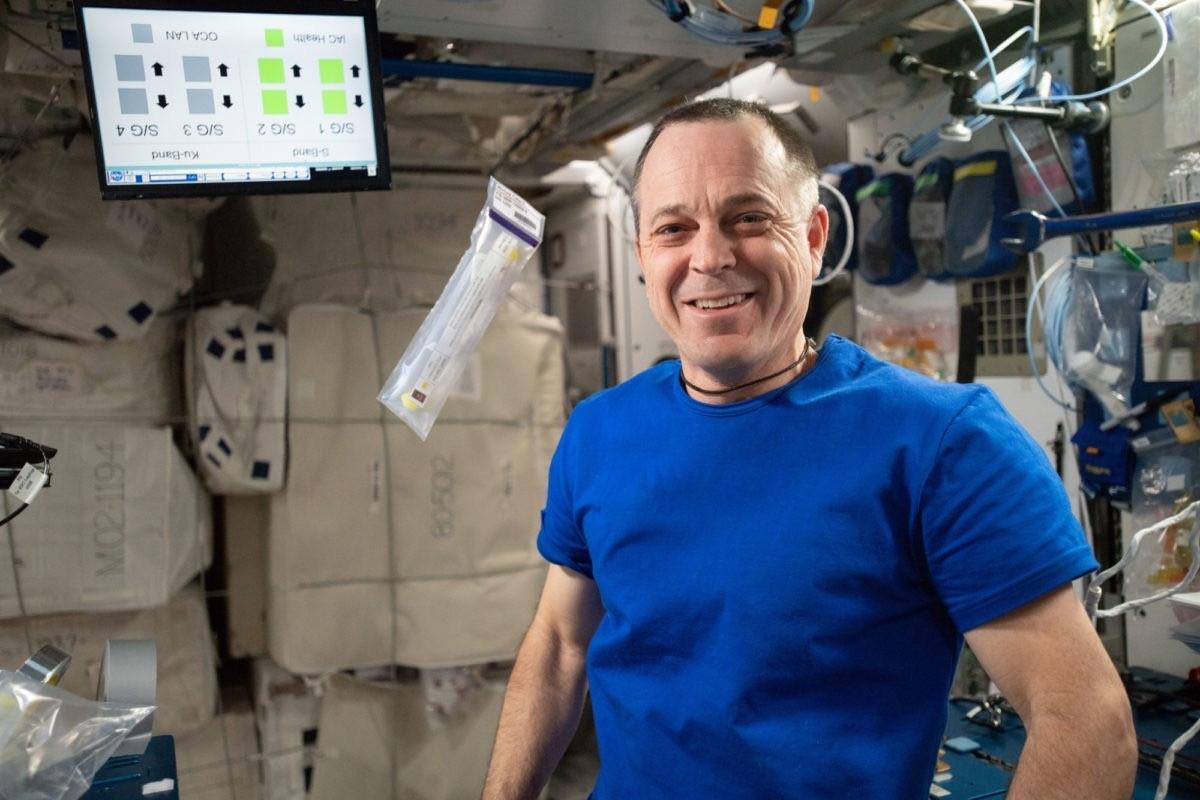 Homem em estação Espacial ao lado de tubo de ensaio
