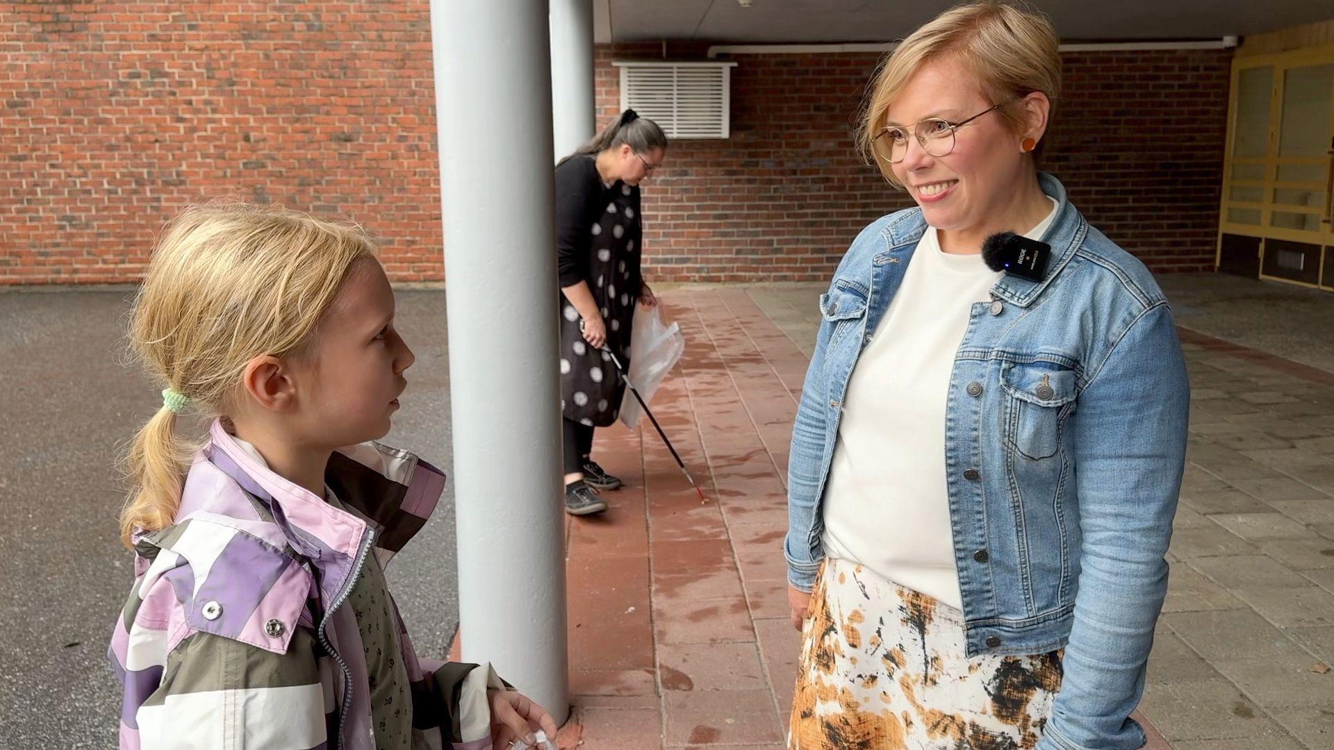 Piia Elo habla con un alumno de 11 años en el patio de la escuela.